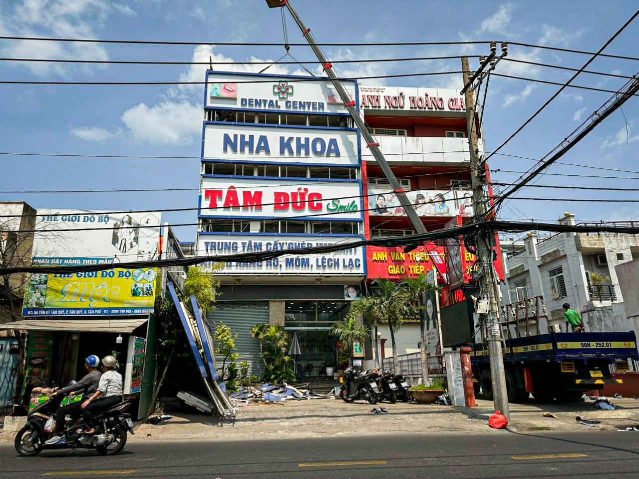 Xe cẩu tự hành Hùng Đạt đang cẩu lắp đặt bảng hiệu quảng cáo ngoài trời